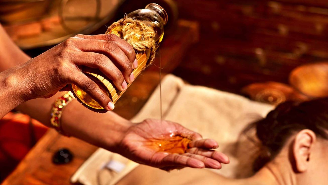 mains appliquants de l'huile sur le dos