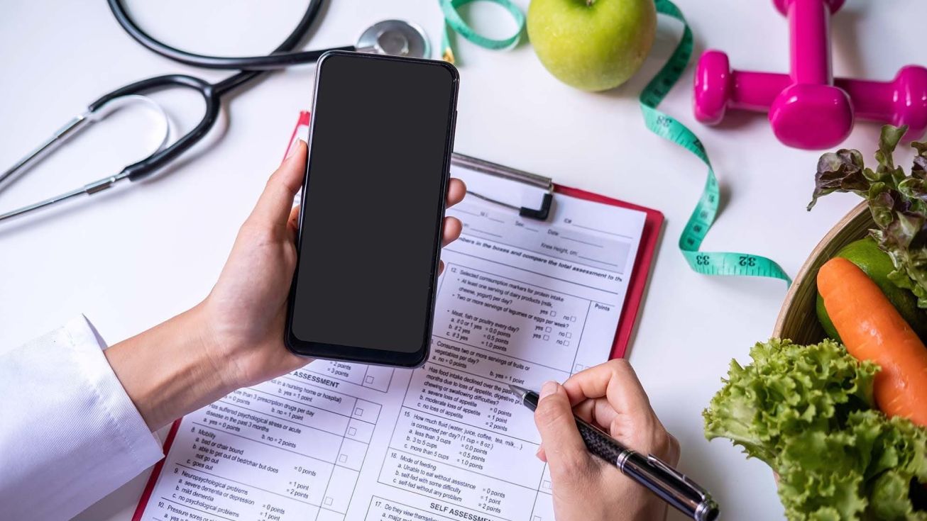 Main d'une personne qui tient un téléphone pour les consultations externes et téléphoniques